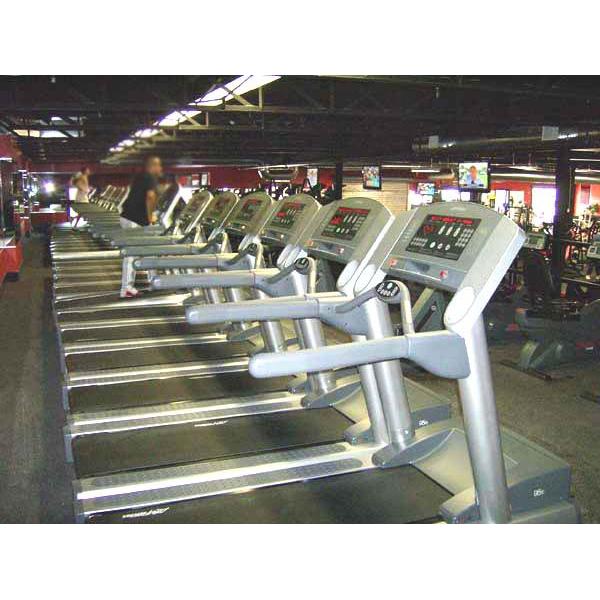 A row of new tread machines in a gym.