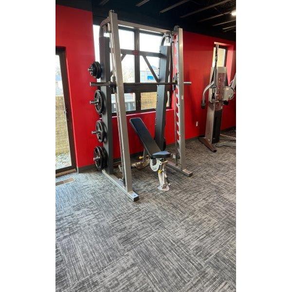 A gym with a squat rack and weights, offering both new and remanufactured gym equipment.