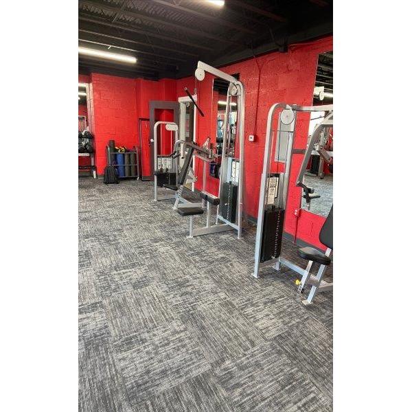 A gym with a red wall and new gym equipment.