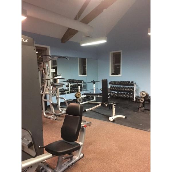 A gym equipped with new weight machines and remanufactured gym equipment, complete with mirrors. A gym equipped with new weight machines and remanufactured gym equipment, complete with mirrors.