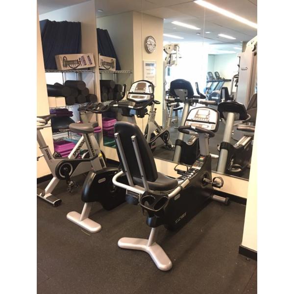 A gym room with several exercise bikes and mirrors featuring new gym equipment. A gym room with several exercise bikes and mirrors featuring new gym equipment.