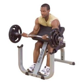 A man using the Body Solid 2" x 3" Heavy Duty Preacher Curl Bench - New to perform a bicep curl on a bench.