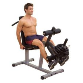A man sitting on a Body Solid Plate Loaded Leg Curl & Extension Machine - New.