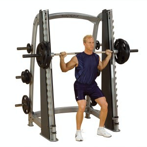 A man is doing a squat on a Body Solid Plate Loaded Pro Clubline Counter Balanced Smith Machine - New.