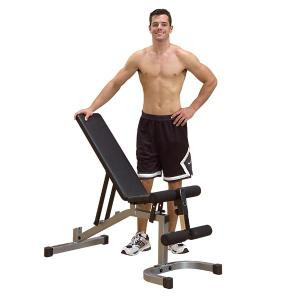 A man standing next to a Body Solid Powerline Flat/Incline/Decline Bench w/ Leg Hold Down - New gym equipment.