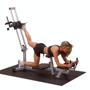 A woman working out on the Body Solid Powerline Glute Max Machine - New, doing leg exercises.