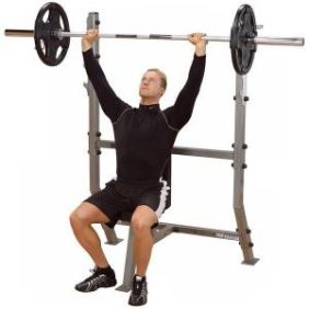 A man performing a barbell squat on a Body Solid Pro Clubline Shoulder Press Olympic Bench - New.