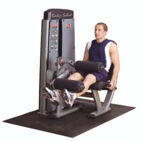 A man is sitting on a Body Solid Selectorized Pro Dual Leg Extension Curl Machine - New.