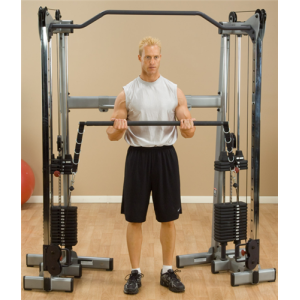A man is standing in front of a Body Solid Dual Press Bar Accessory - New gym machine.
