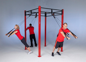 A group of people utilizing the CrossCore® Rotational Bodyweight Training™ Modular Rack to perform pull ups in a state-of-the-art gym.