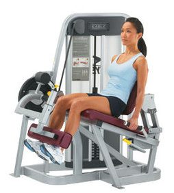 A woman sitting on a Cybex Eagle Selectorized Leg Extension - Remanufactured.