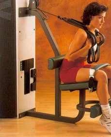 A woman is sitting on a bench with a Cybex Modular Abdominal- Remanufactured attached to it, using new gym equipment.