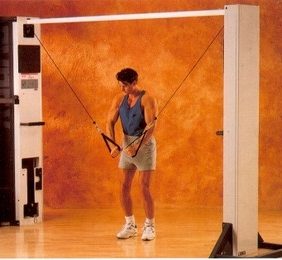 A man is using the Cybex Modular Cable Crossover - Remanufactured machine in a gym.