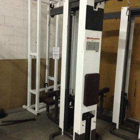 A selection of new and Cybex Modular Lat Pulldown and Tricep Push Down C/S - Remanufactured gym equipment in a spacious warehouse.