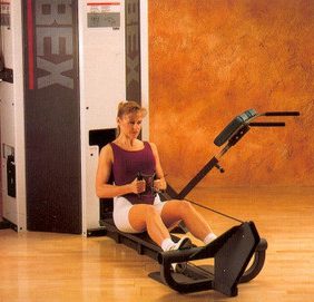 A woman sitting on a Cybex Modular Low Pulley- Remanufactured in a gym.