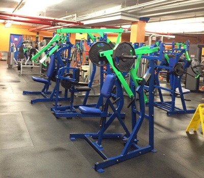 A gym with new and remanufactured green and blue equipment in it.
