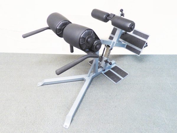 A gym machine with a pair of M.A.S.S. Glutes-Back Plus - New dumbbells on it.