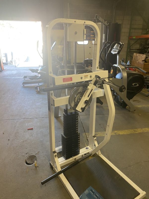 A warehouse filled with new and remanufactured gym equipment, including a Paramount Multi Hip - Remanufactured machine.