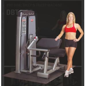 A woman is posing next to a new Body Solid DBTC-SF Pro Dual Bicep/Tricep Machine.