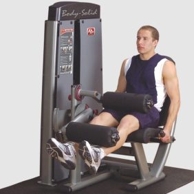 A man is sitting on a Body Solid DLEC-SF Pro Dual Leg Extension/Curl Machine.