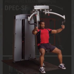 A man is doing a chest press on the Body Solid DPEC-SF Pro Dual Pec/Rear Delt Machine at the gym.