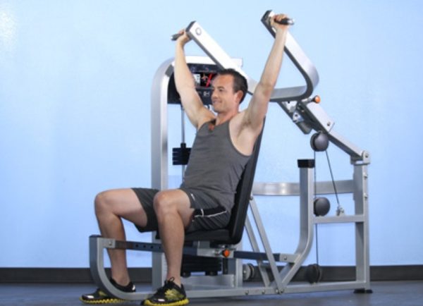 A man is engaged in a chest press using the Muscle D Fitness Multi Press COMBO MACHINE.