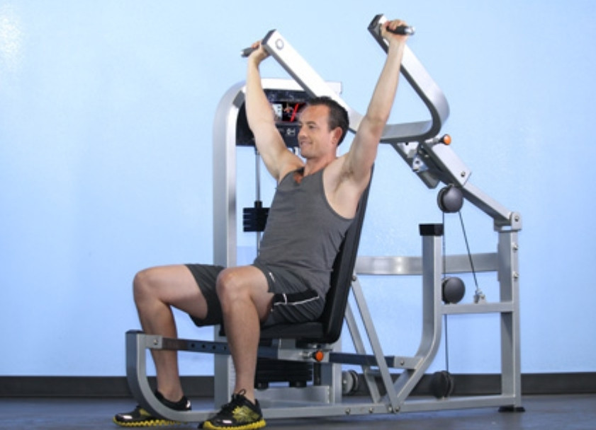 A man is engaged in a chest press using the Muscle D Fitness Multi Press COMBO MACHINE.