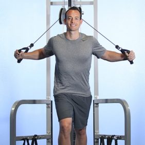 A man standing in front of a Muscle D Fitness High Low Pulley COMBO MACHINE.