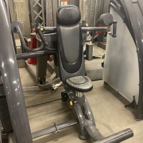 A new Sports Art Independent Shoulder Press - As Is Functional gym machine is sitting in a room with other equipment.