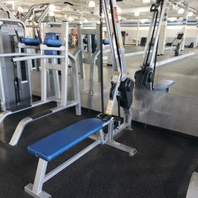 A gym with the Marpo Kinetics Rope Climber - Serviced including a bench, weights, and mirrors.