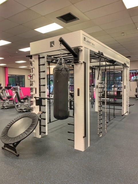 A gym featuring a variety of boxing bag and other equipment, including both new and the Queenax Functional Training System - As Is Functional.
