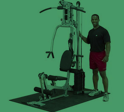 A man standing next to a new gym machine.