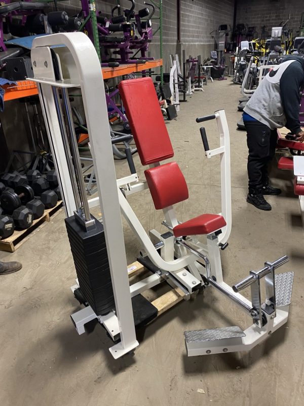 A new red and white gym machine in a warehouse.