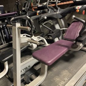 A group of The Abs Co. The Abs Bench - As Is Functional, new and remanufactured gym equipment, in a gym with purple seats.
