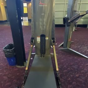 The Freemotion Lift - As Is Functional exercise machine sits elegantly on a maroon carpeted floor, featuring various straps and a padded bench for ultimate comfort.