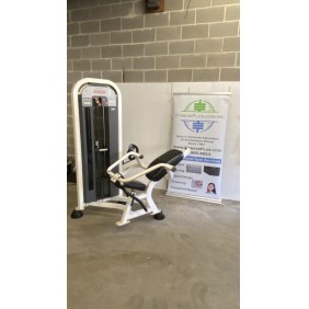 A Star Trac Abdominal - As Is Functional banner hangs proudly near a brick wall, complementing the seated exercise machine's sleek design—a perfect blend of innovation and style for any fitness enthusiast.