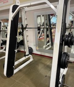 Package $65,000 Smith machine with weights in a gym, mirror reflecting your progress in the background.