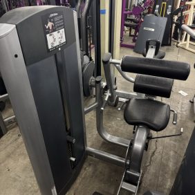 A Hoist Roc-It PL Bicep Curl machine, featuring the Functional design with black cushions and a sturdy metal frame, is located in a fitness facility.